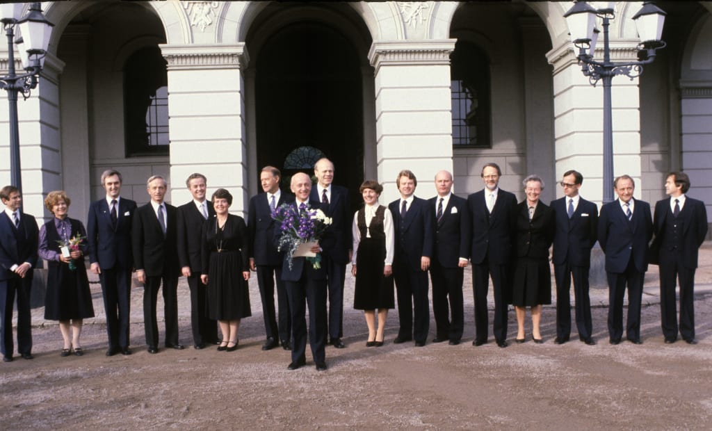 Foto av Statsminister Kåre Willoch med sin regjering på Slottsplassen etter regjeringen Willochs første statsråd. 
